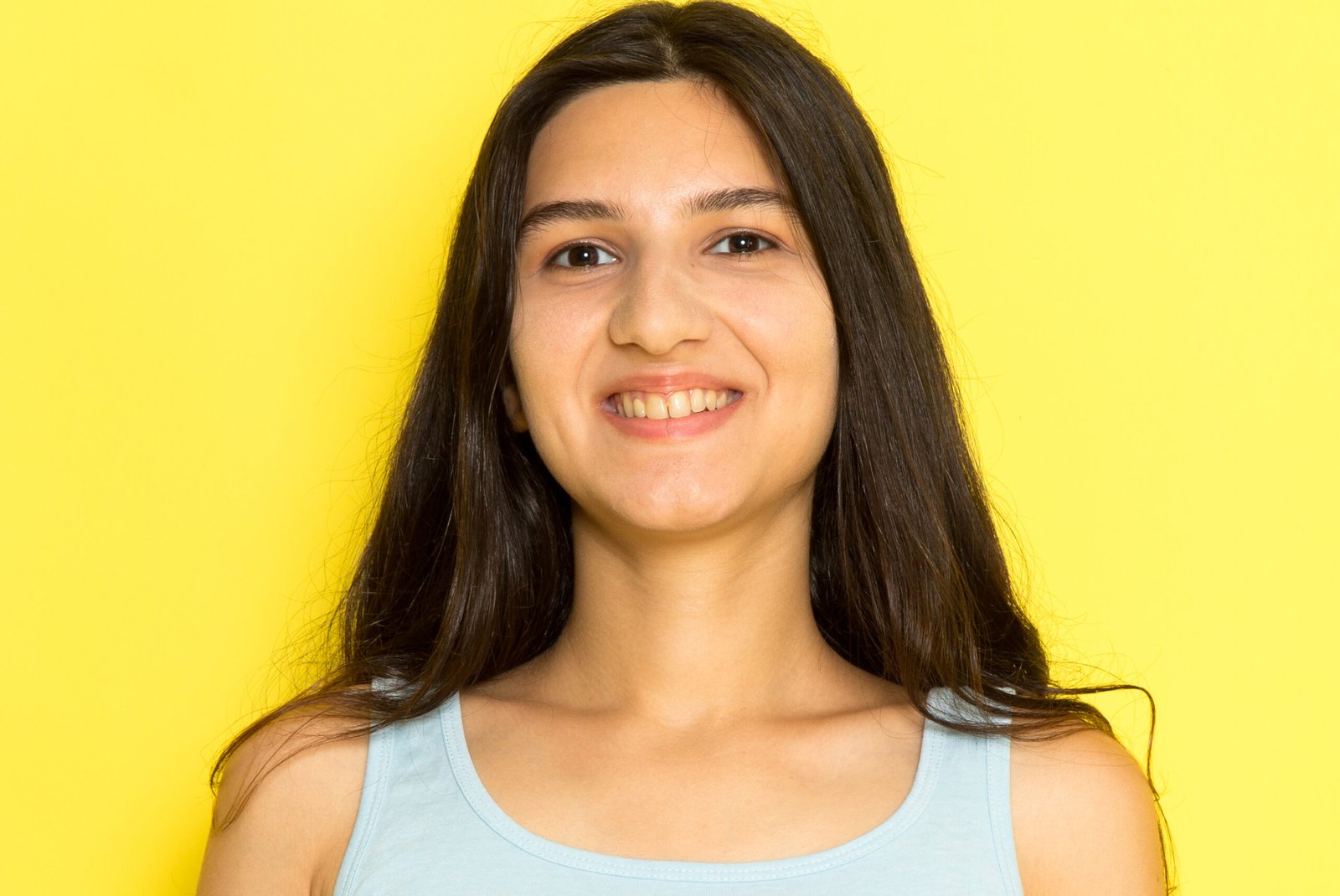 front-view-young-female-blue-shirt-smiling-yellow-background-girl-pose-model-beauty-young (1) (1)